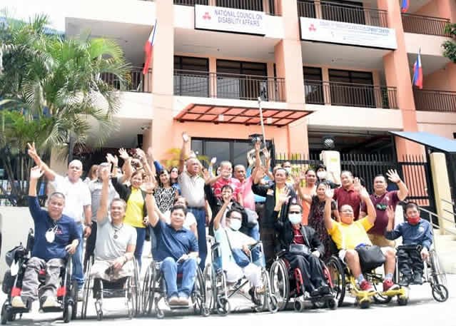 Persons With Disabilities and their companions pose in front of DRDC building